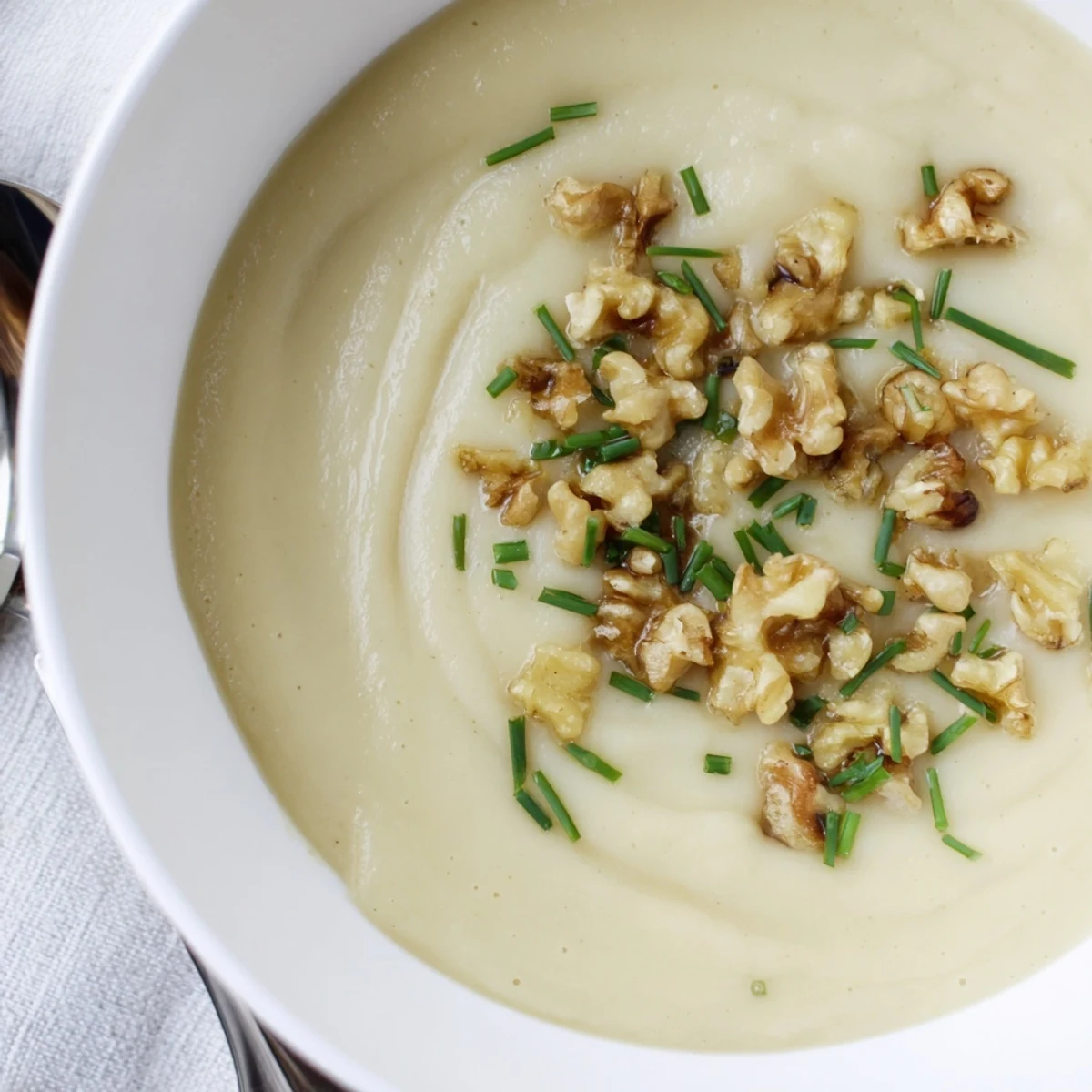 Creamy Parsnip and Pear Soup served warm in a rustic bowl beside crusty artisan bread.