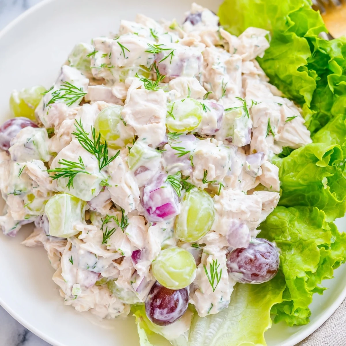 Creamy chicken salad with crisp celery in a white bowl on a rustic table