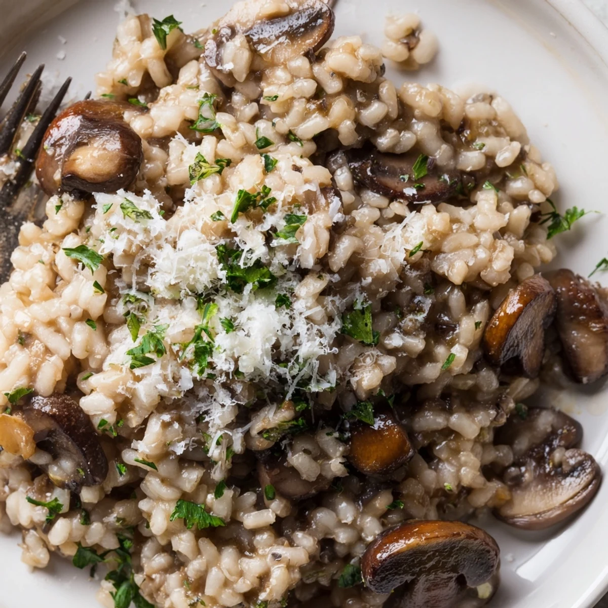 A rich bowl of Creamy Mushroom Risotto with Truffle Oil beside a glass of white wine on a rustic table.