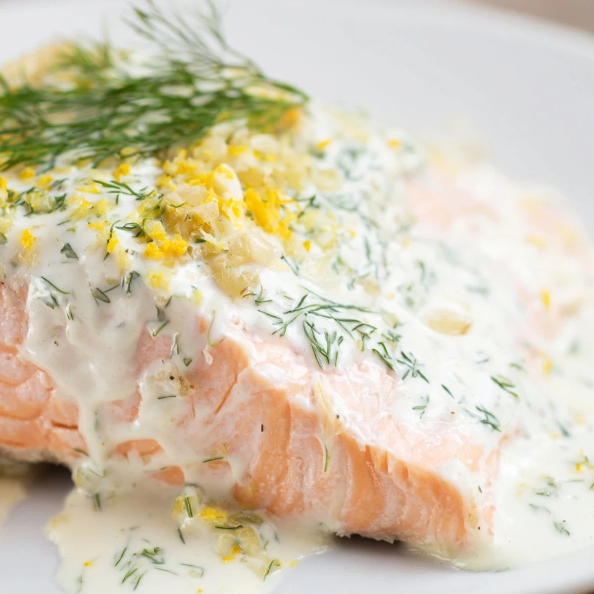 Flaky Baked Salmon with Garlic Butter and Dill Sauce served with roasted asparagus and lemon wedges.