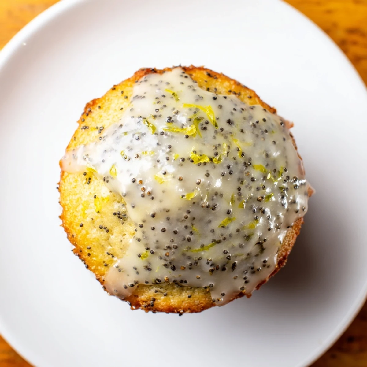 Twelve golden Lemon Poppy Seed Muffins with Lemon Glaze line a wire cooling rack, glistening with sweet citrus icing for breakfast.