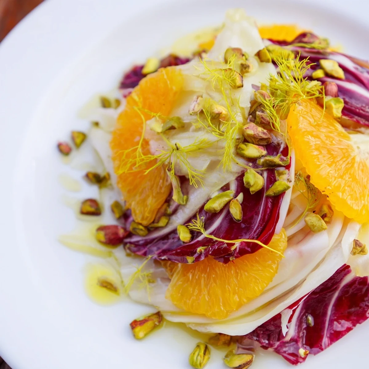 Bright Winter Citrus Salad with Radicchio and Fennel showcases juicy citrus slices, crisp fennel, and toasted pistachios on a platter, drizzled with zesty vinaigrette.  