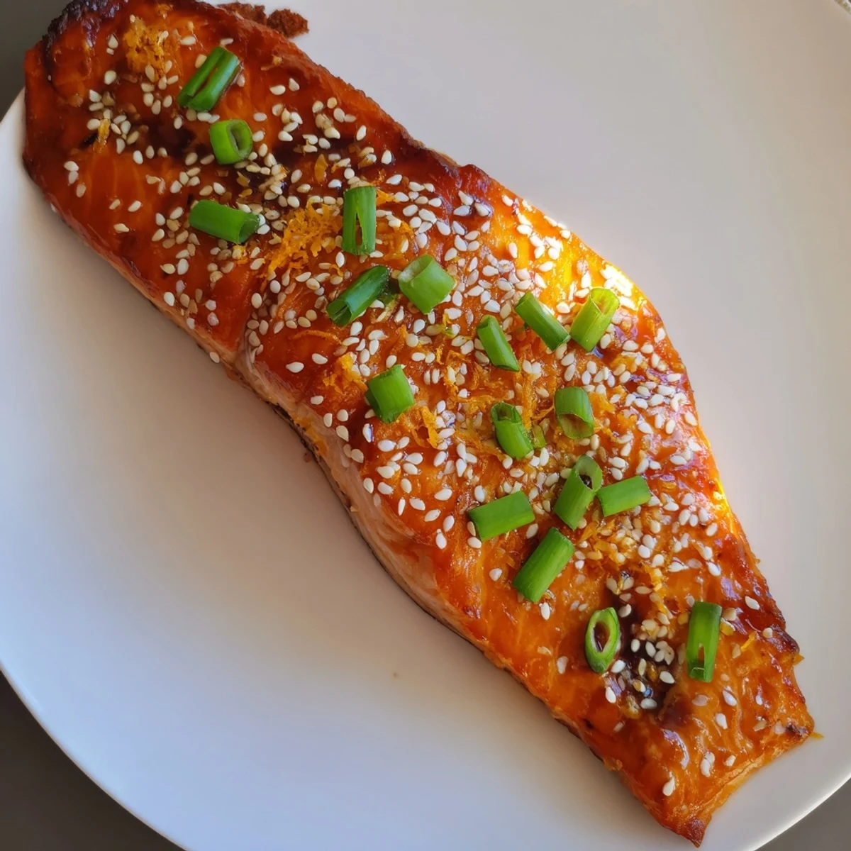 Baked salmon with orange ginger glaze, a vibrant main dish for a healthy, elegant meal served with rice.