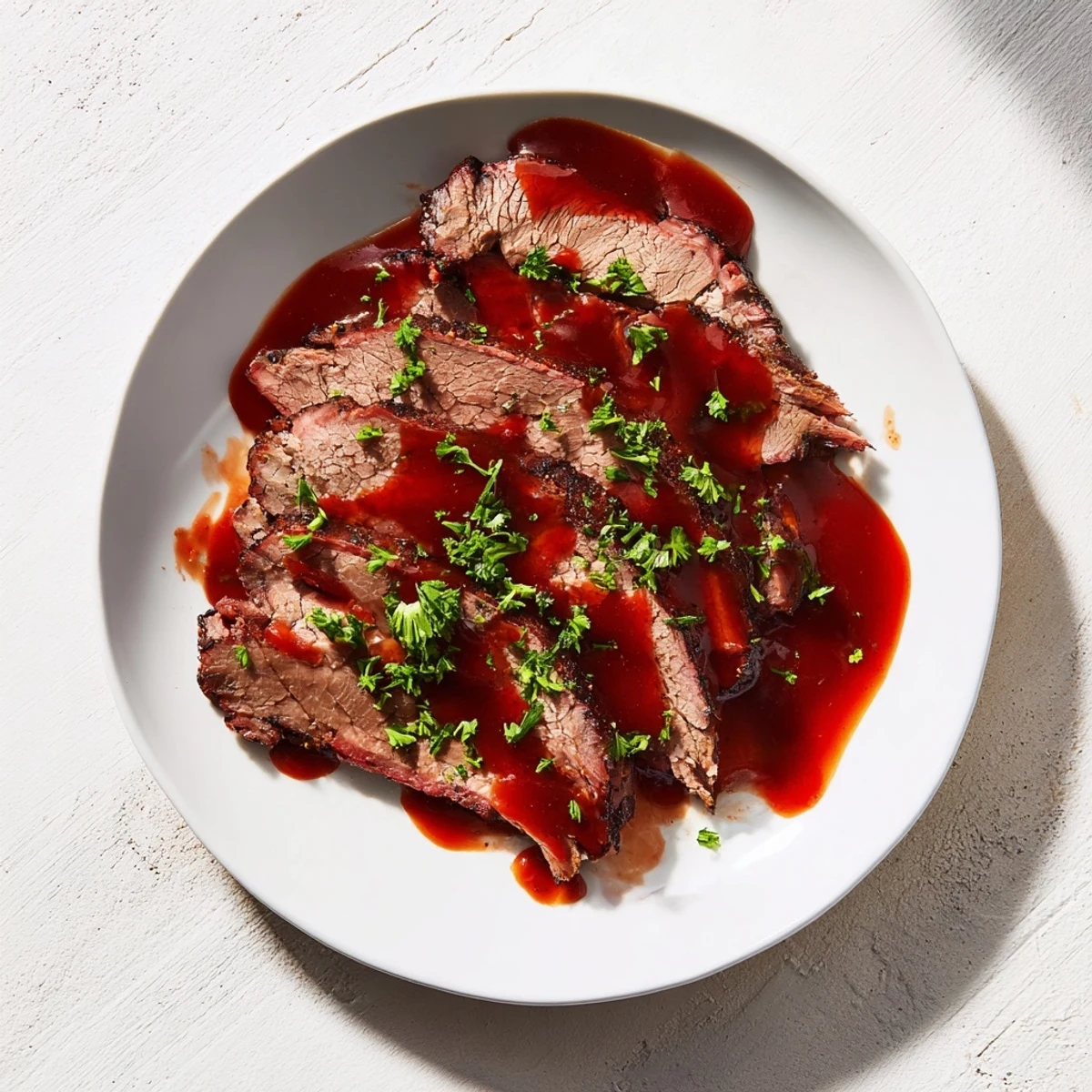 Slow-cooked beef brisket glistening with homemade BBQ sauce, ready to be served on a soft bun for a hearty meal.  