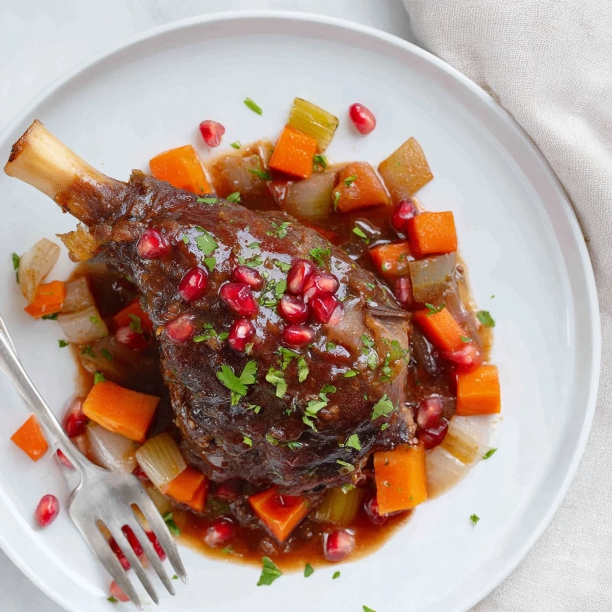 Tender Braised Lamb Shanks with Pomegranate Glaze are finished with a thick, tangy sauce, resting on a dark plate ready for a hearty meal.