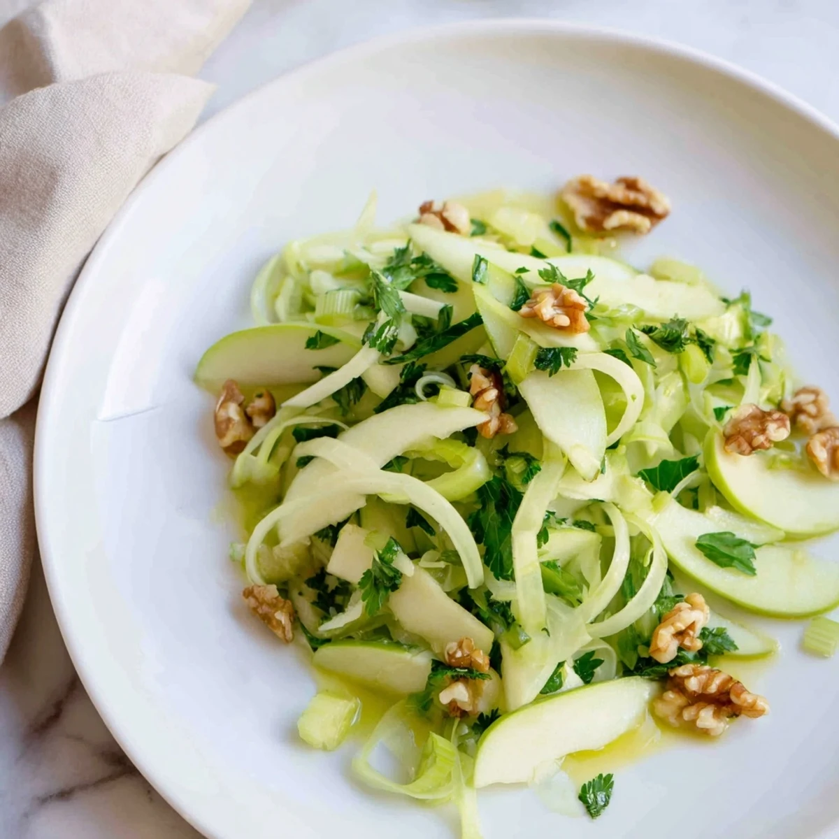 Freshly tossed Green Apple and Celery Salad with crisp slices and a glossy lemon-honey dressing in a rustic bowl.