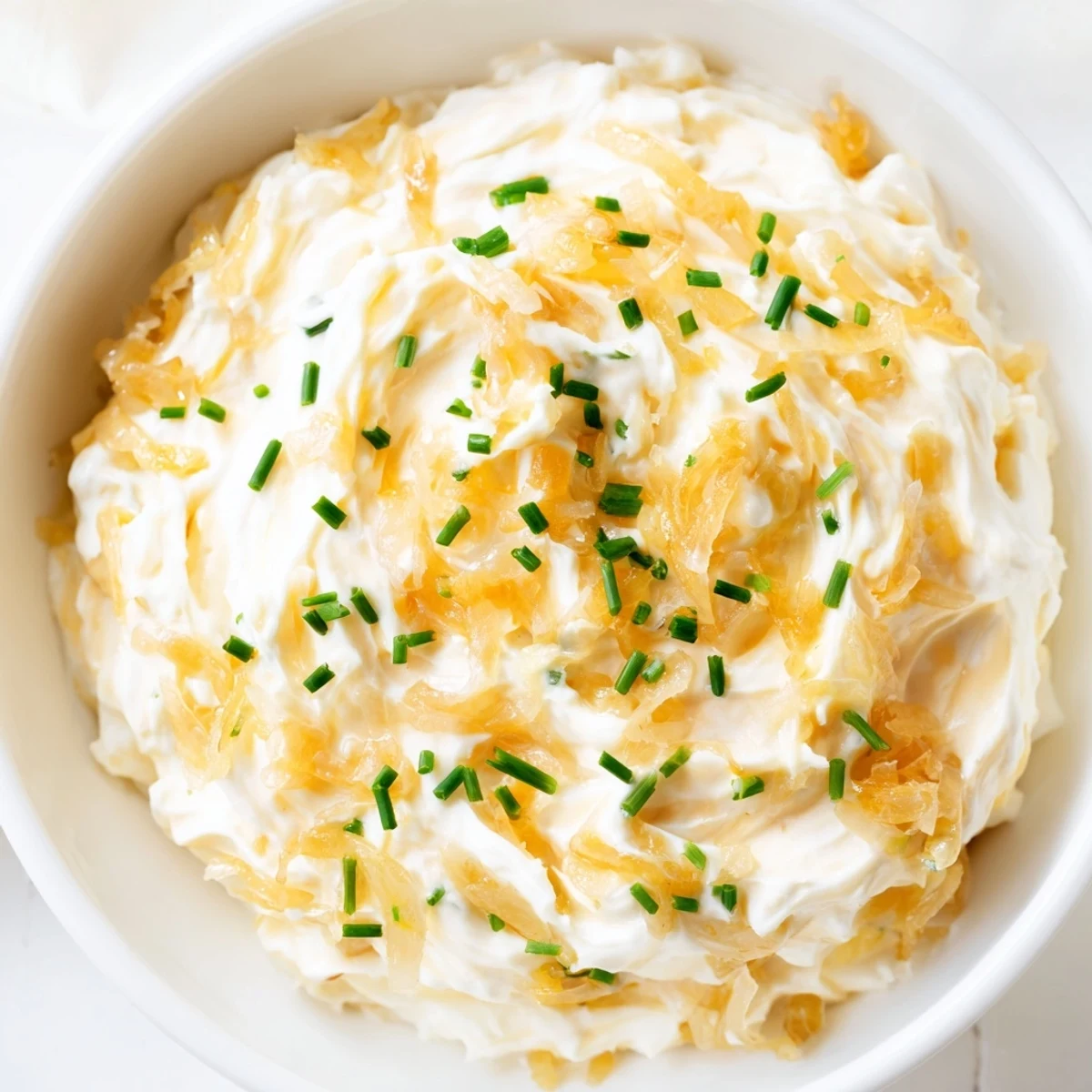 Golden caramelized onions folded into creamy Game Day Onion Dip, served in a bowl with crunchy kettle chips. 