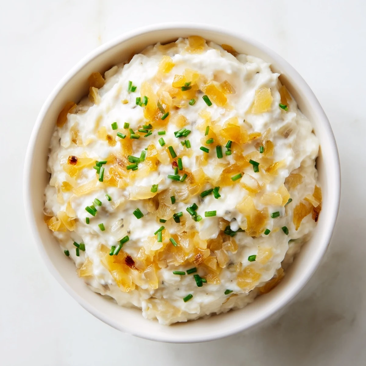 Rich, savory Game Day Onion Dip with deep caramelized onion flavor, paired with crispy chips on a serving platter.