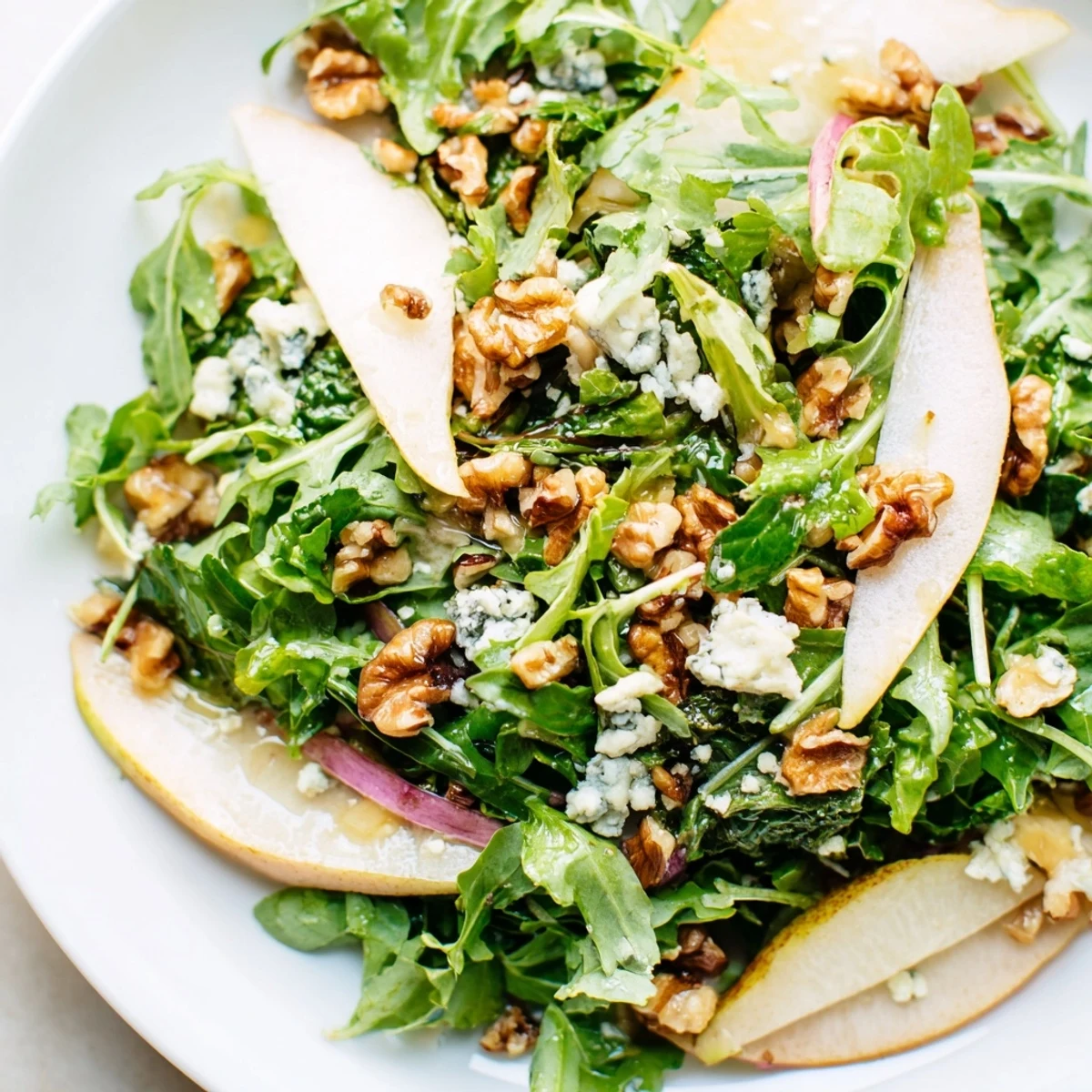 Fresh Winter Green Salad with Pear and Walnuts features crisp greens, juicy sliced pears, toasted nuts, and creamy blue cheese.  
