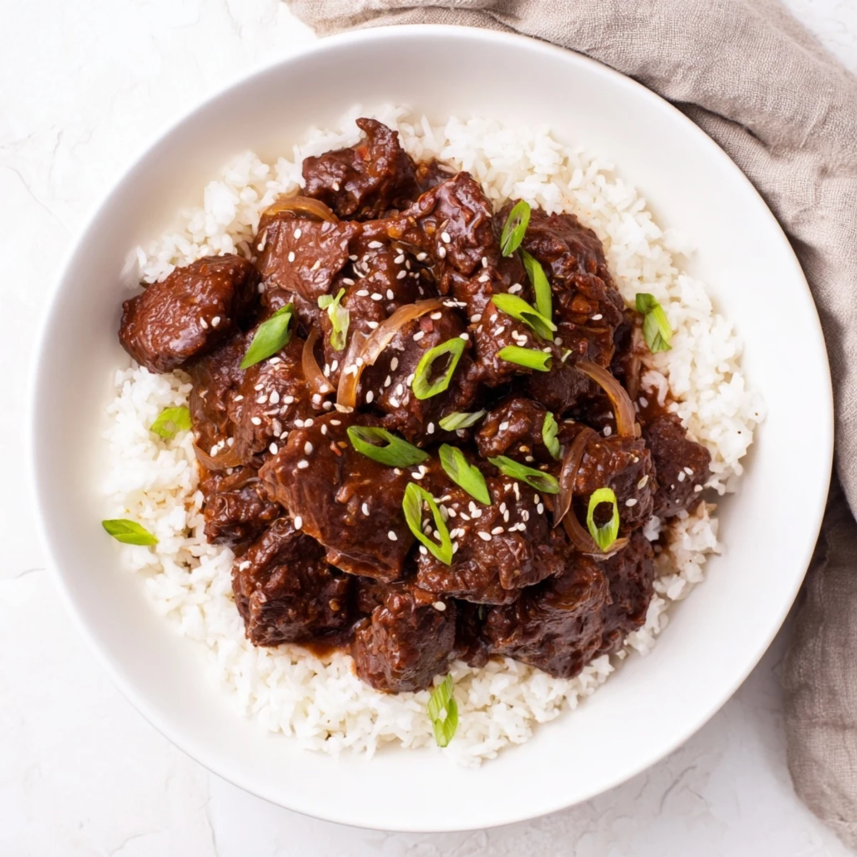 Close-up of slow-cooked Korean Beef, savory and glossy, served on a plate with a side of steamed rice for dinner.