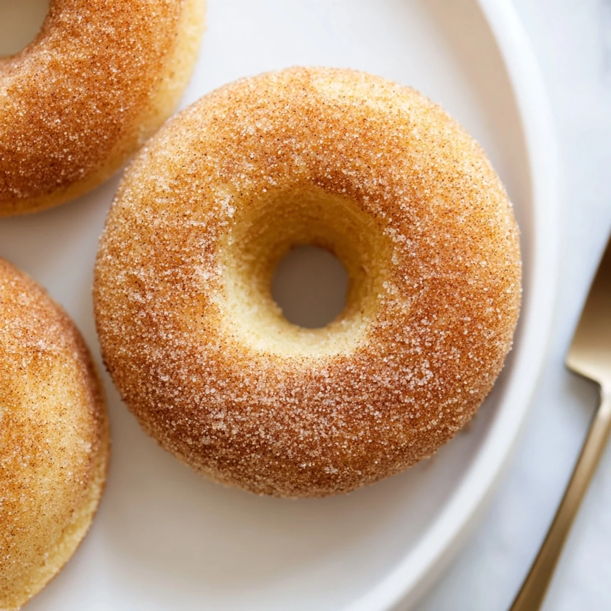 A platter of Delicious Baked Cinnamon Sugar Donuts You Cant Resist paired with a steaming mug of coffee for breakfast.