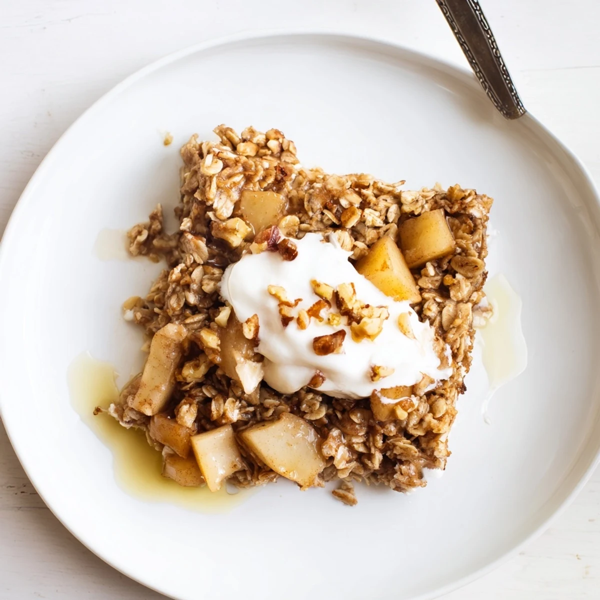 A close-up view of Baked Apple Oatmeal With Greek Yogurt, highlighting the creamy yogurt topping and golden baked texture.