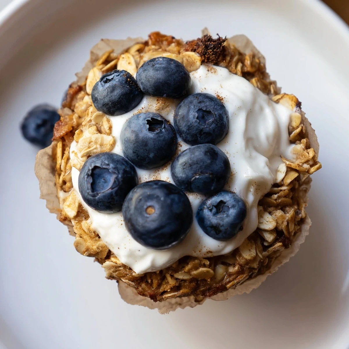 Golden brown Baked Oatmeal Cups with Greek Yogurt garnished with berries, ideal for an on-the-go morning meal.