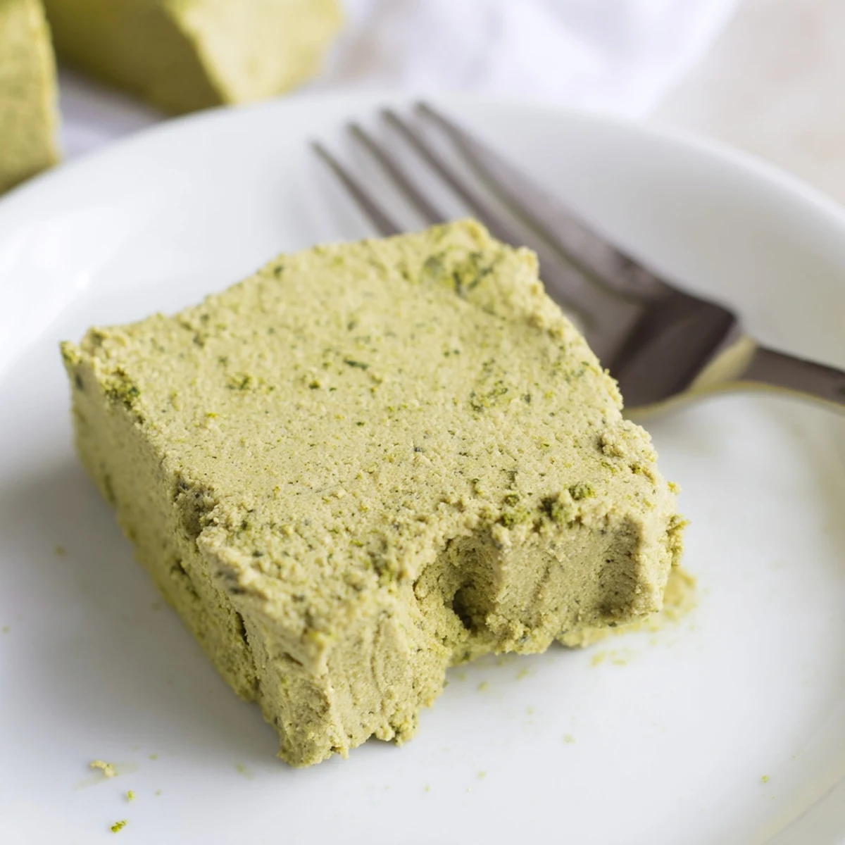 Sliced 5-Ingredient Matcha Halva served on a white plate, showcasing its soft, melt-in-your-mouth layers.