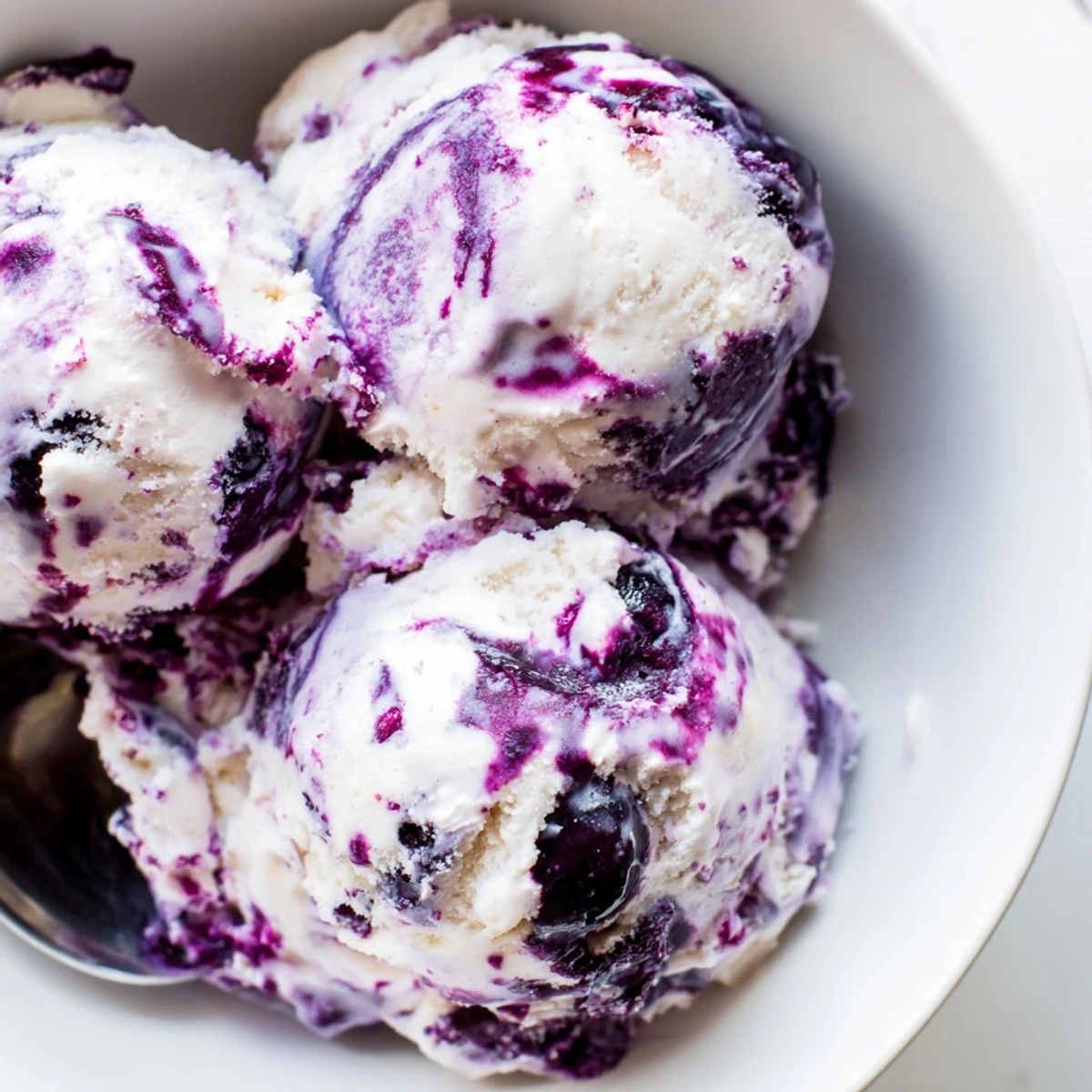 Blueberry Cottage Cheese Ice Cream in a loaf pan, garnished with fresh blueberries and mint leaves for a refreshing summer treat.