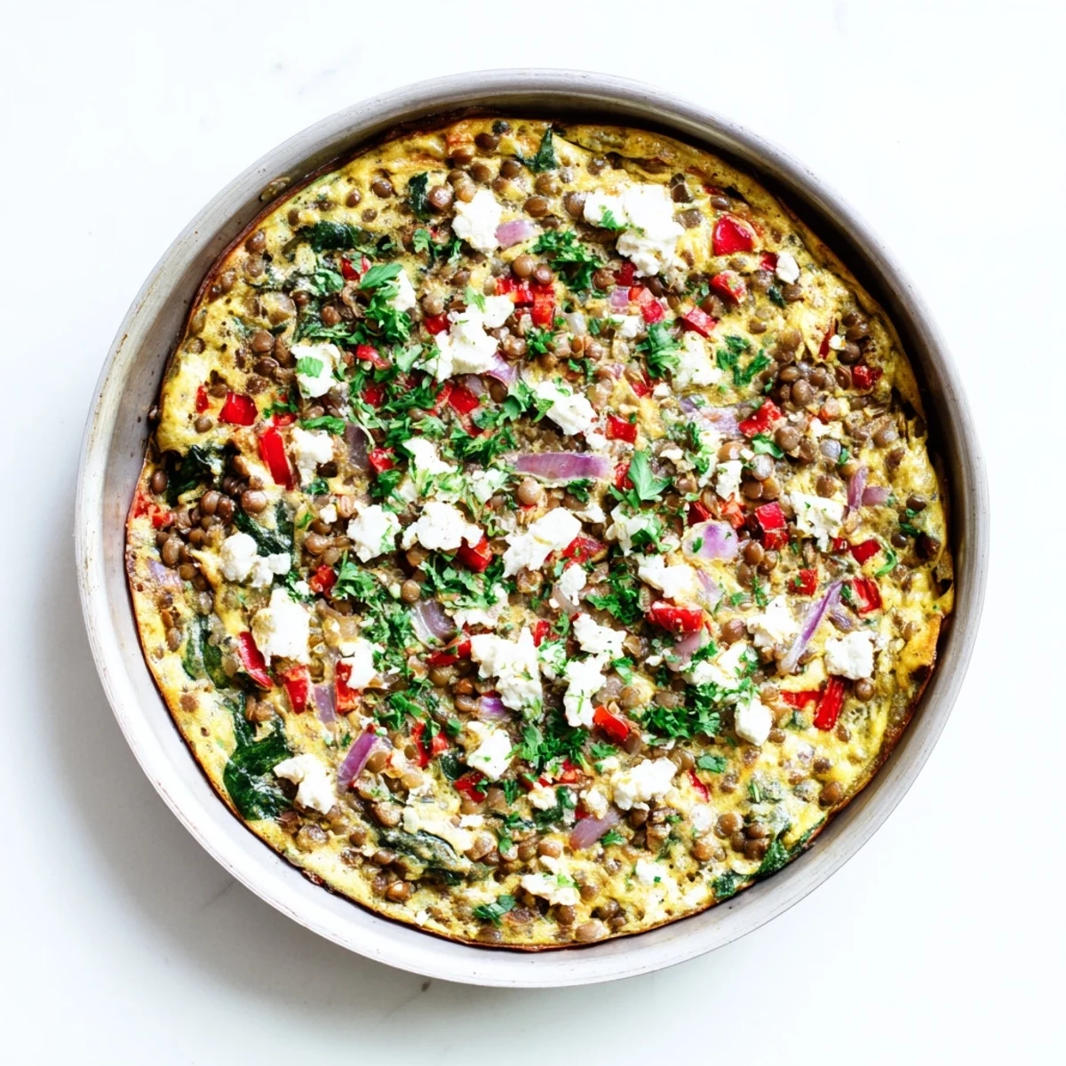 Serving suggestion for Healthy Lentil and Frittata, featuring tender lentils and diced red peppers on a rustic wooden board.