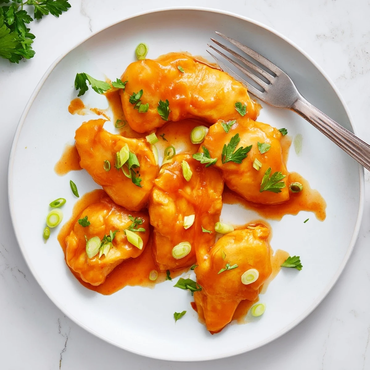 Classic Apricot Chicken served over fluffy white rice with fresh parsley and green onions.