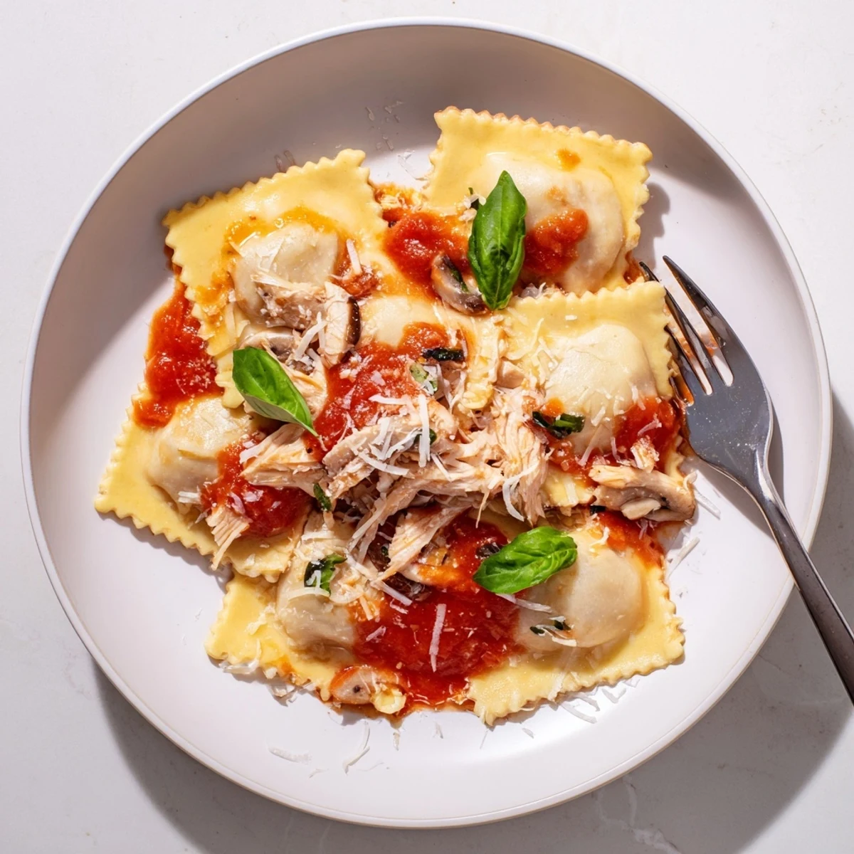 Homemade Chicken and Mushroom Ravioli with Simple Tomato Sauce served steaming hot, ready to enjoy for a comforting Italian dinner.