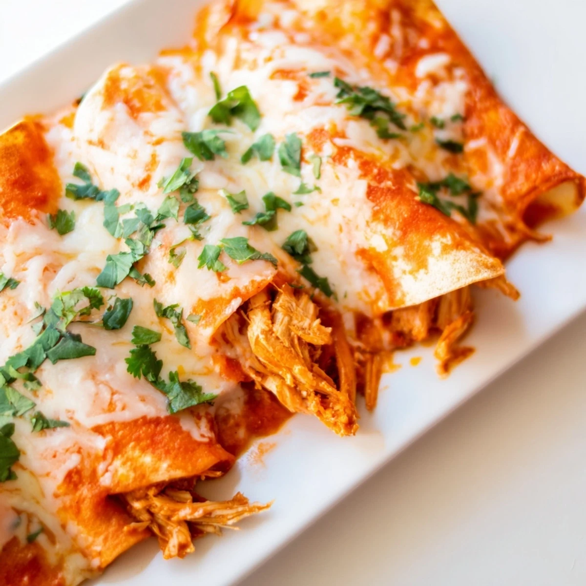 Rolled flour tortillas filled with seasoned shredded chicken topped with enchilada sauce and Mexican cheese blend