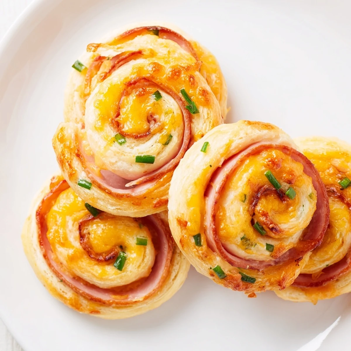 Festive Easter ham cheddar pinwheels arranged on a serving platter for spring entertaining