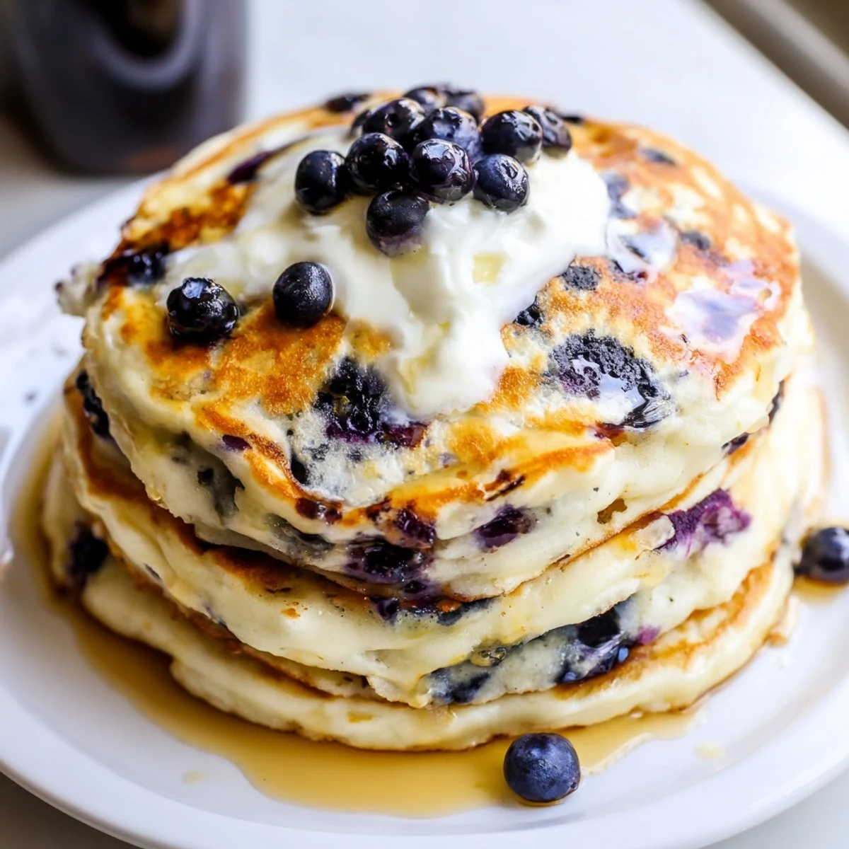 Rustic wooden table displaying Greek yogurt blueberry pancakes drizzled with sweet honey