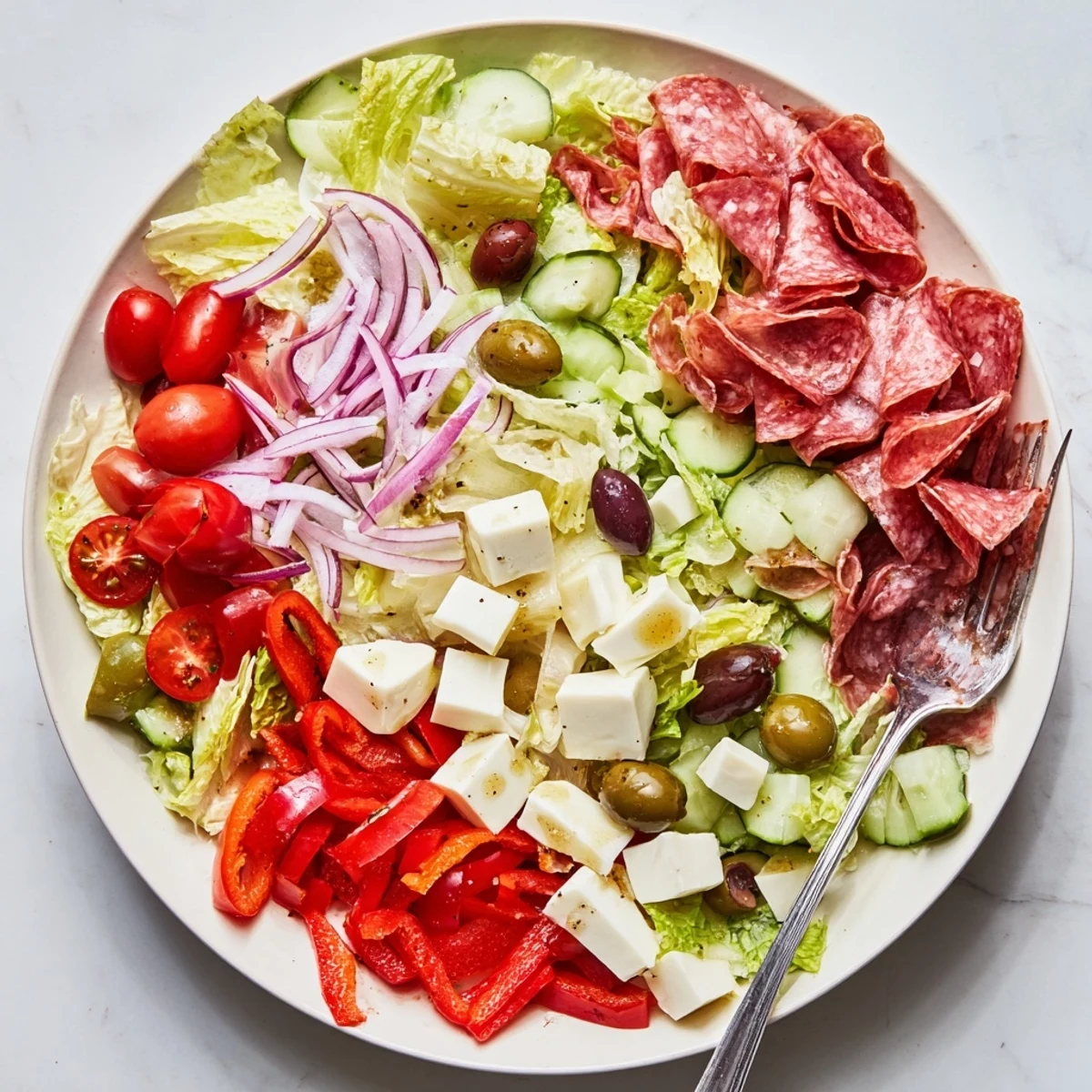 Vibrant Italian chopped salad with fresh vegetables, salami, and mozzarella in zesty homemade dressing