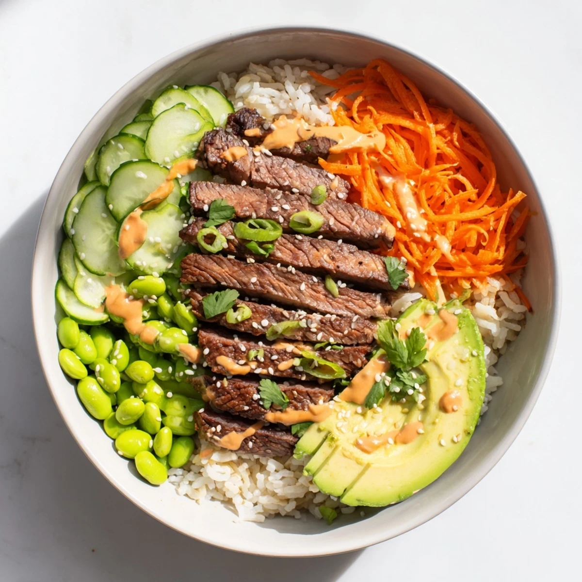 Colorful rice bowl topped with tender grilled flank steak, crunchy vegetables, and sesame seeds