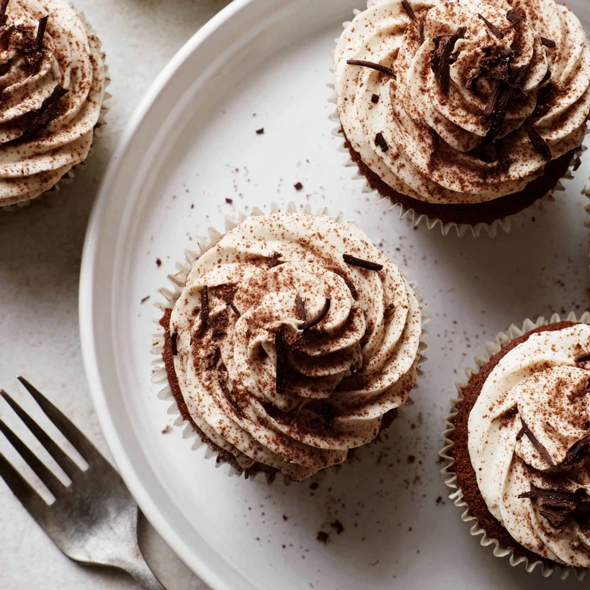 Rich chocolate tiramisu cupcakes topped with fluffy mascarpone frosting and dusted cocoa powder