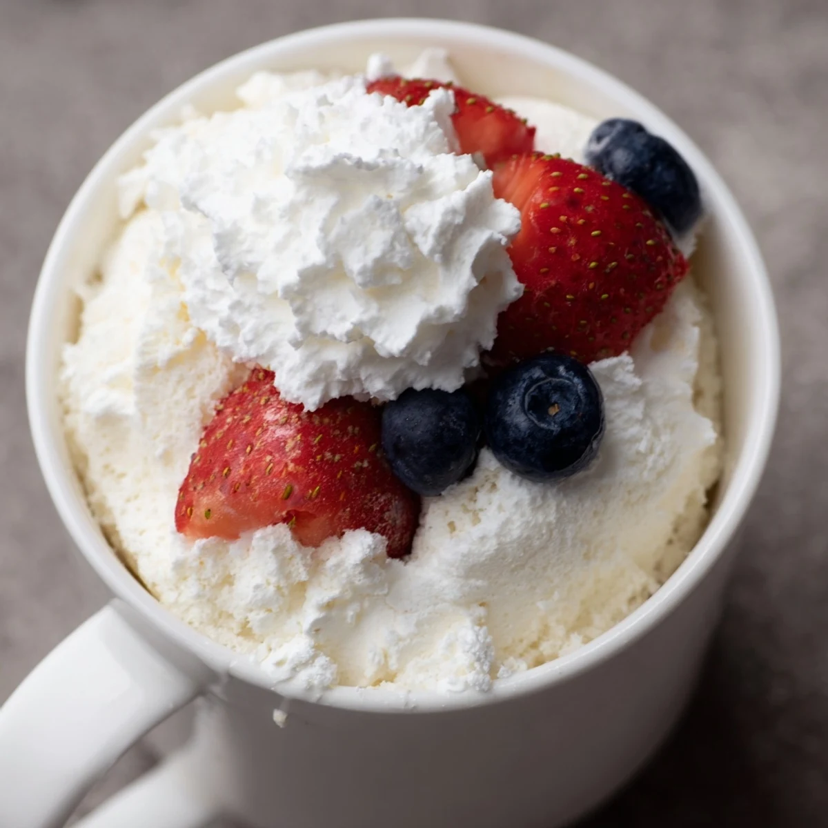 Single-serving air fryer angel food cake with fluffy white texture and berry garnish
