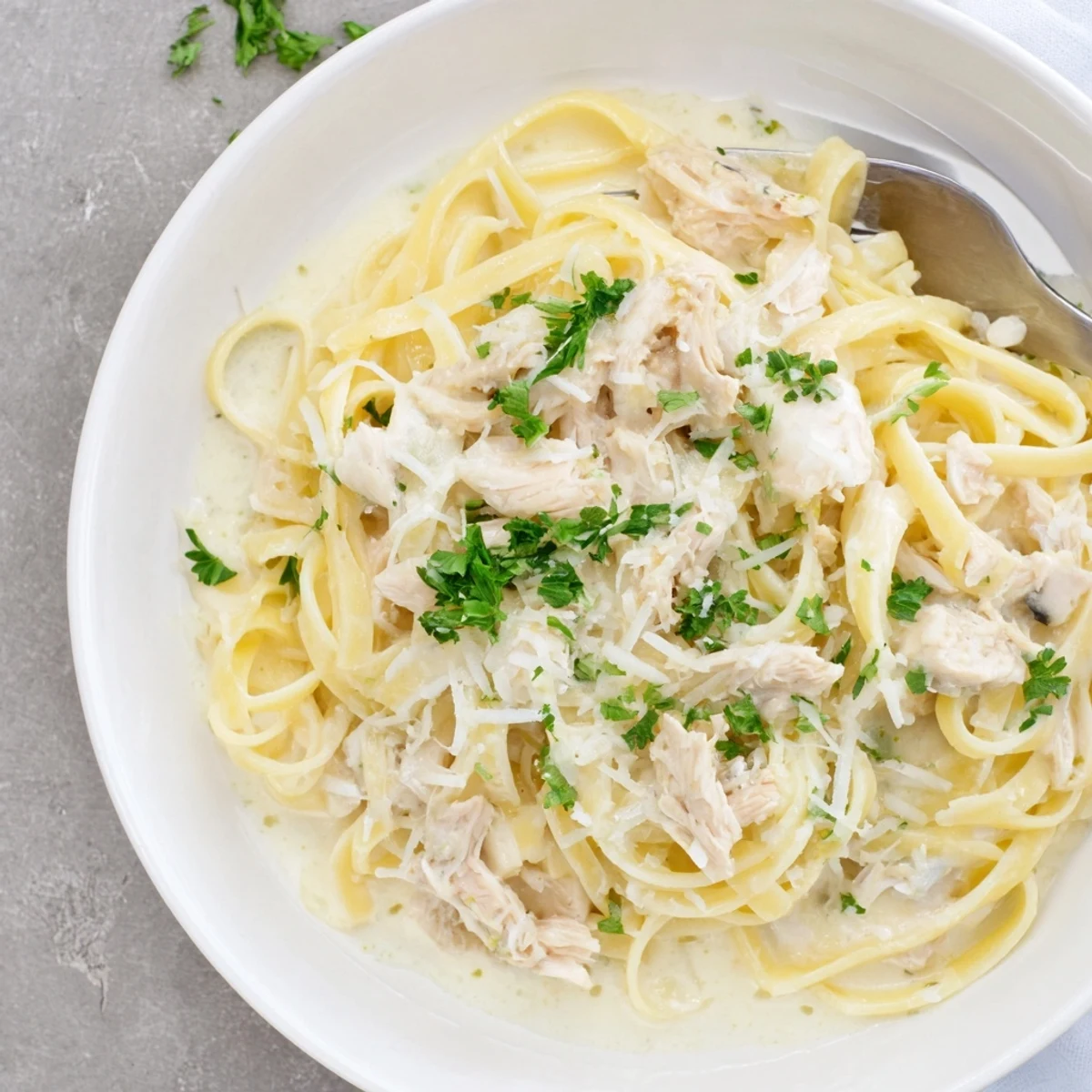 Creamy Crock Pot Chicken Alfredo with tender shredded pasta in a rich white sauce.