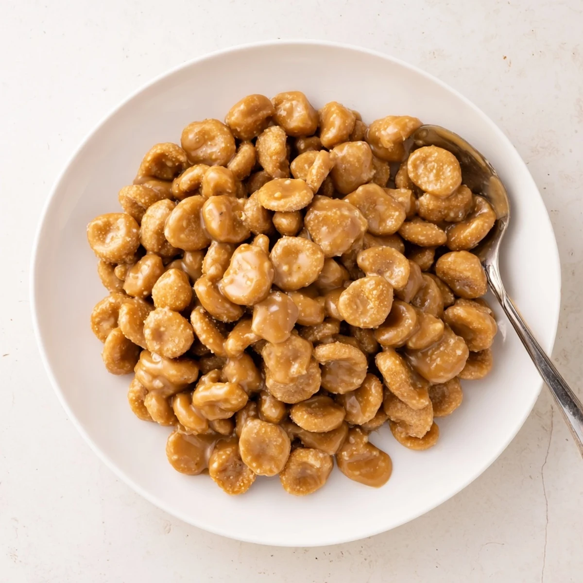 Sweet and salty caramel oyster crackers spilling from a glass bowl, ready for snacking