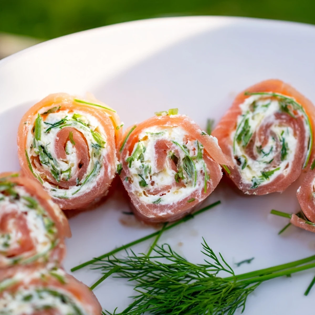 Colorful smoked salmon roll ups pinwheels garnished with fresh dill on wooden board