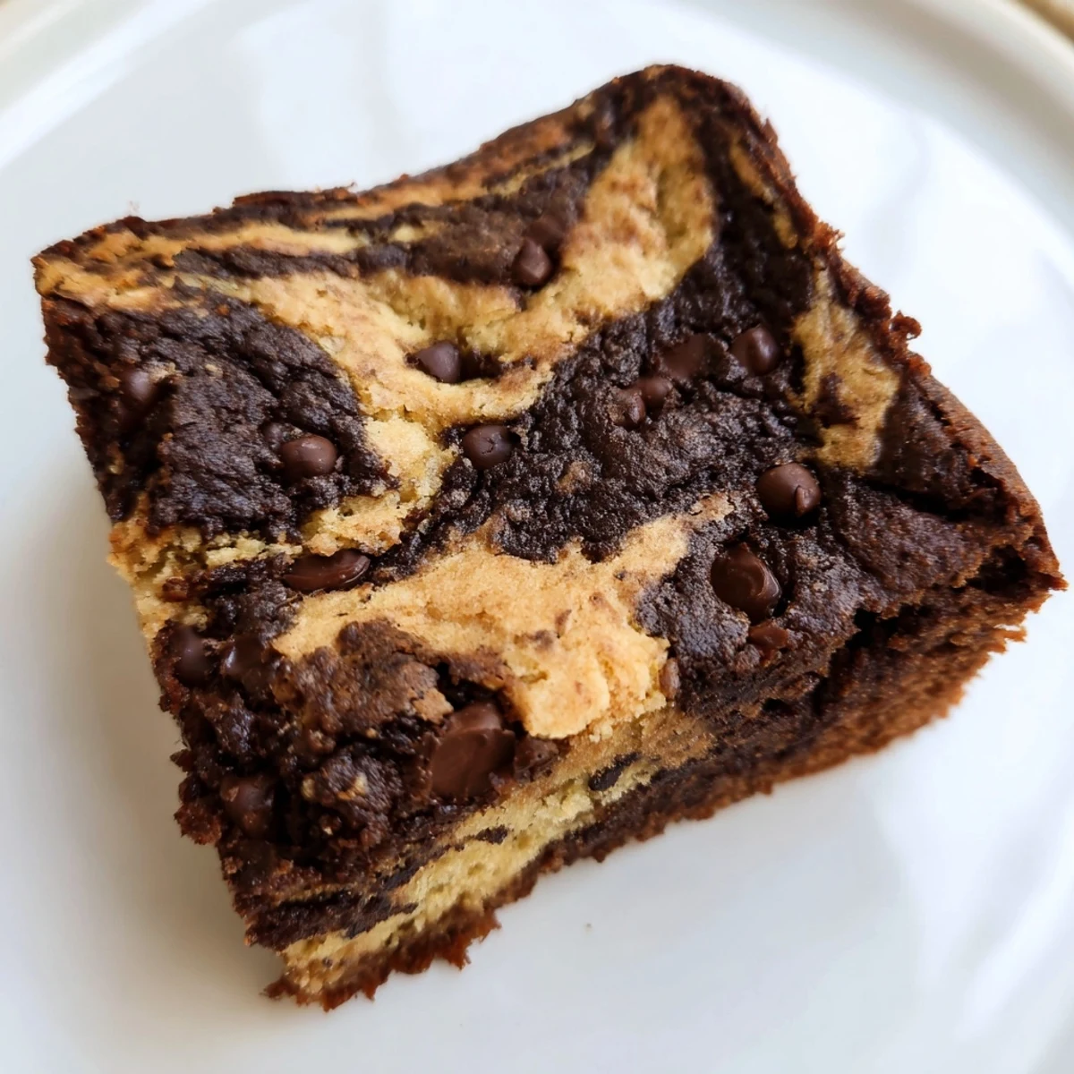 Moist marbled banana bread brownie squares topped with melted chocolate chips and sliced bananas