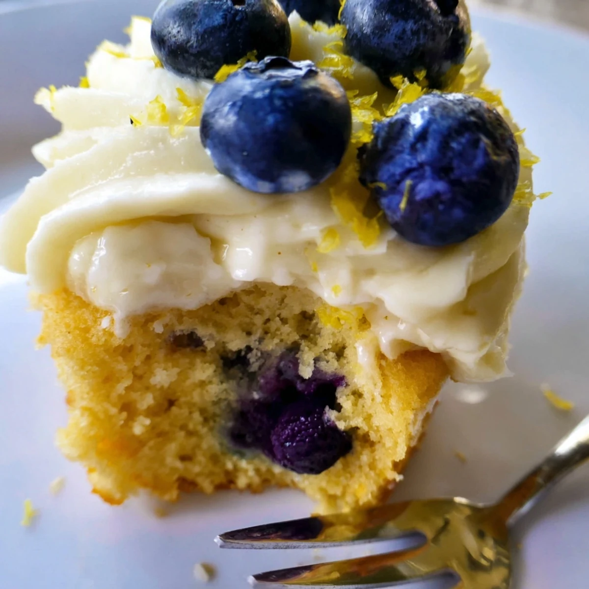 Light and fluffy lemon blueberry cupcakes with fresh berries swirled into golden baked cake