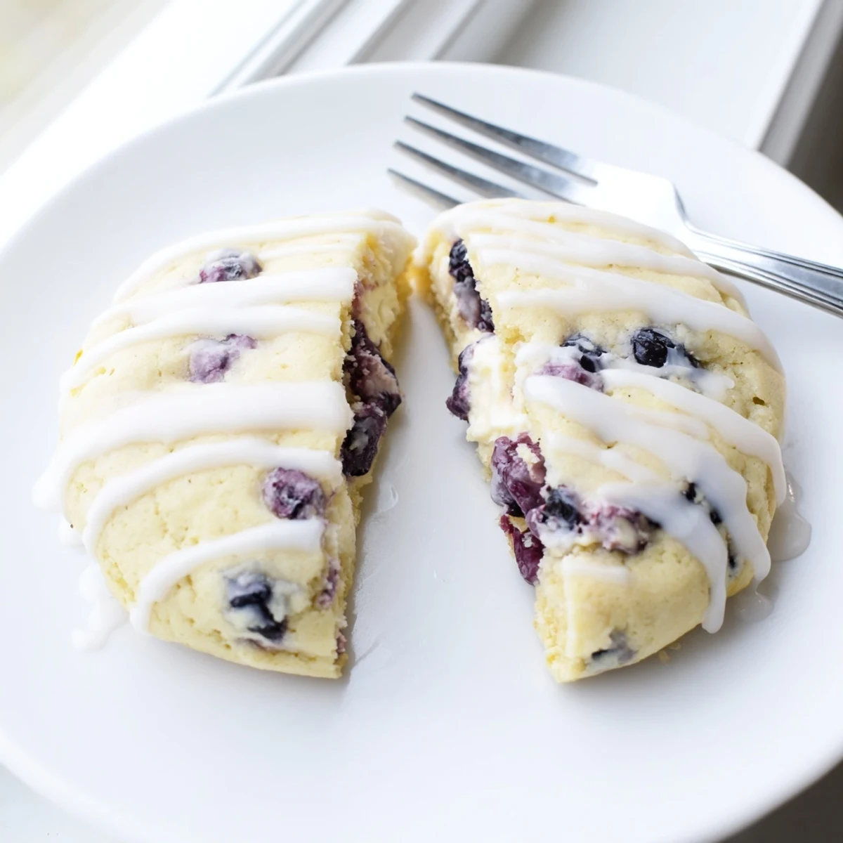 Stack of lemon blueberry cheesecake cookies showing golden crusts and purple berries