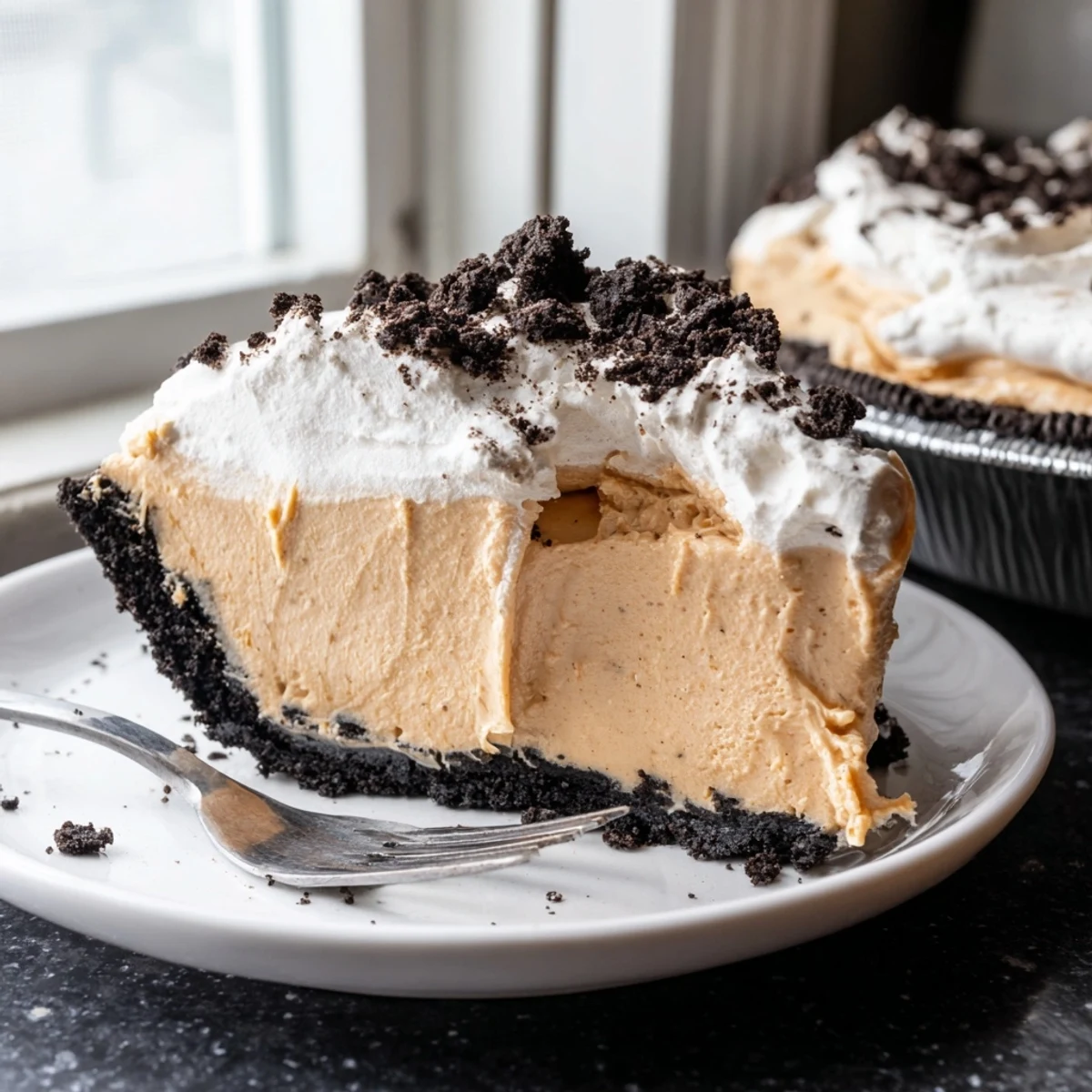 Silky peanut butter filling in a chocolate Oreo crust topped with fluffy whipped cream