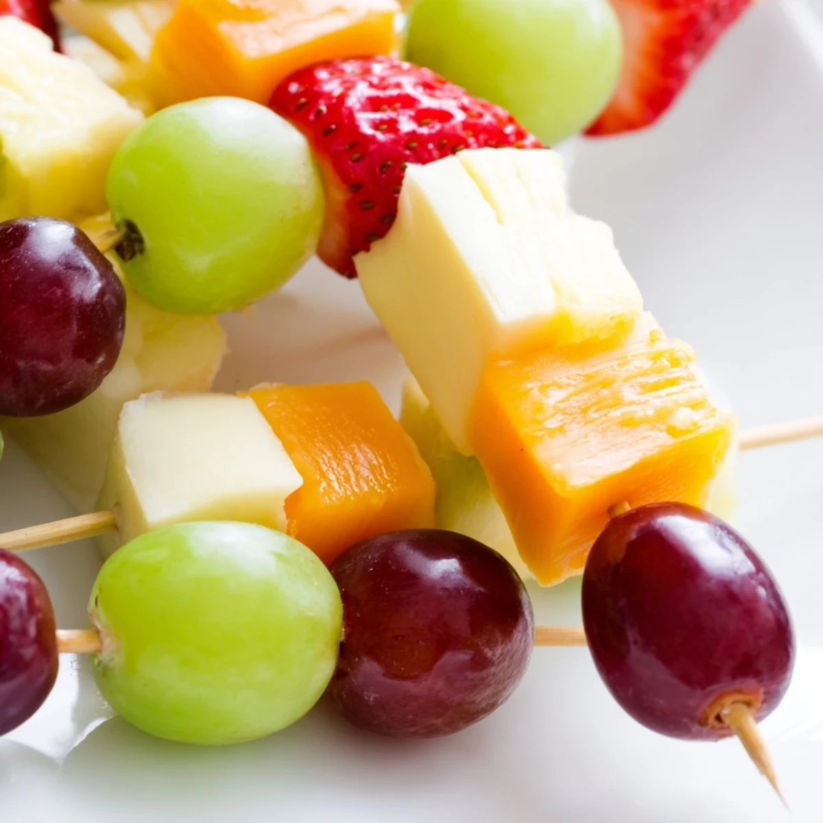 Fresh fruit and cheese kabobs featuring red grapes pineapple and cheddar on skewers