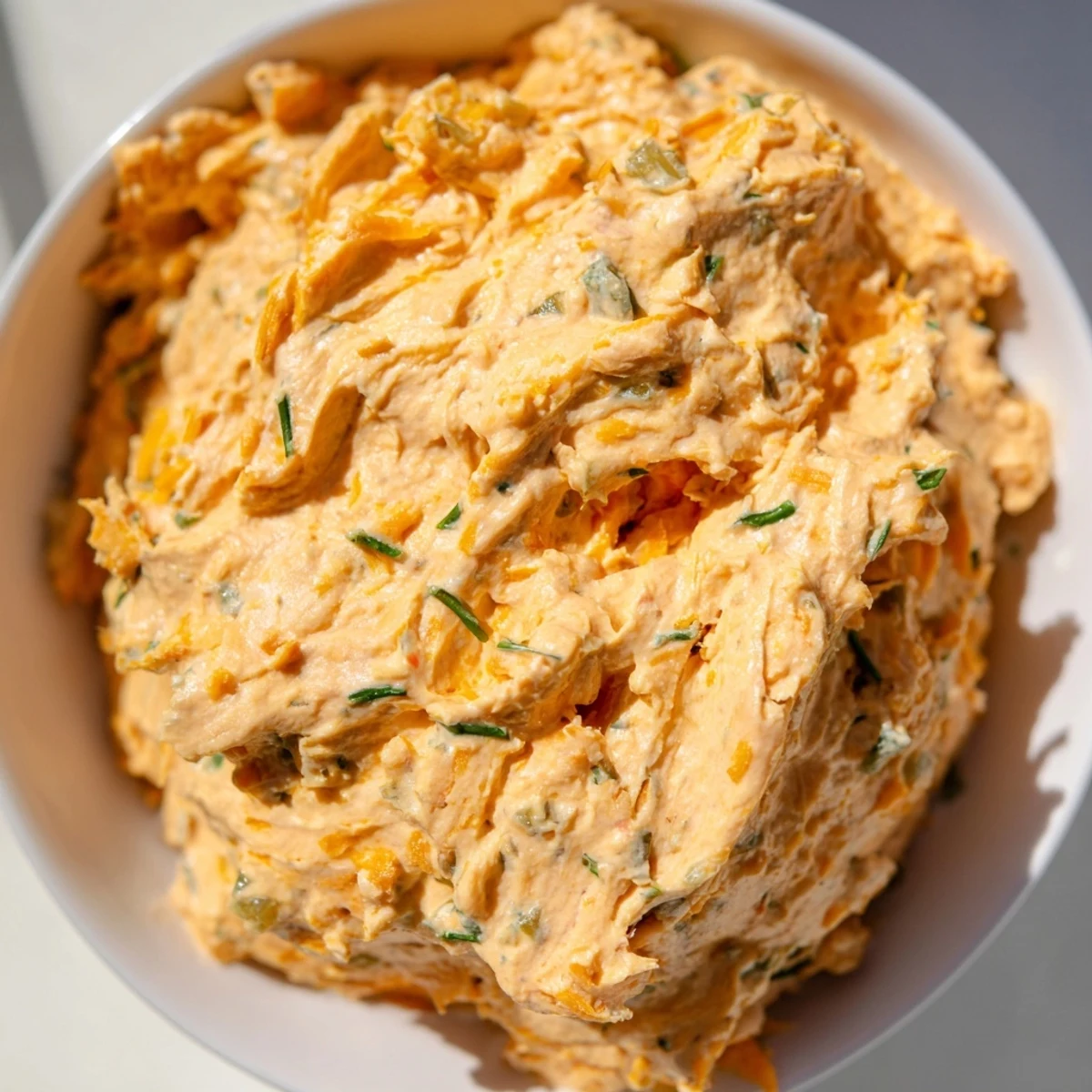 Tangy buffalo pickle dip topped with cheddar cheese and fresh chives ready for game day snacking