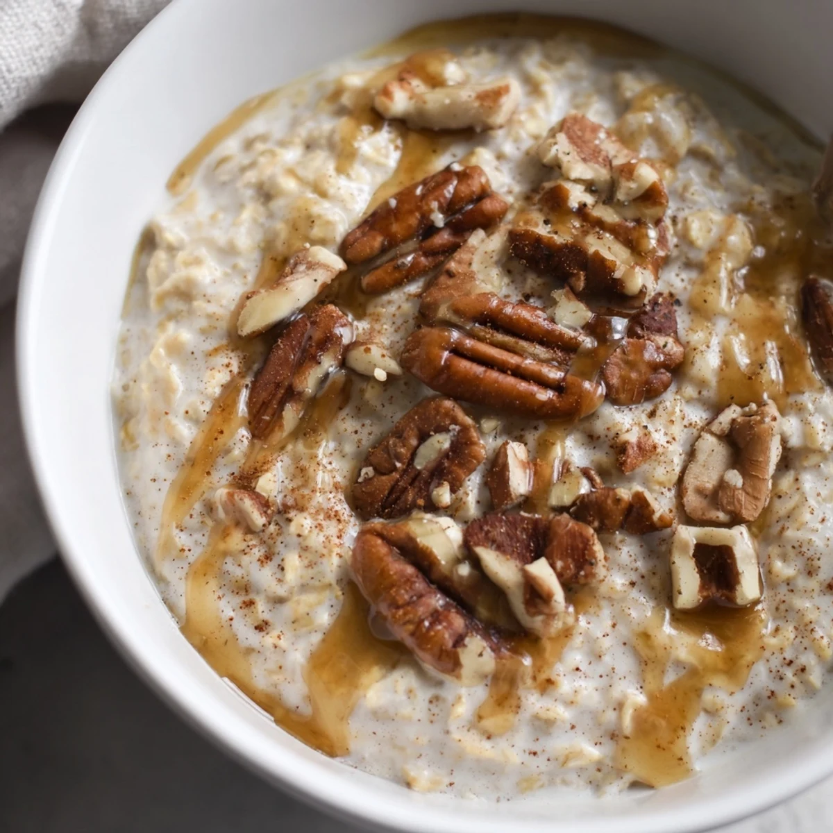 Maple cinnamon pecan overnight oats served in mason jars with a sprinkle of cinnamon