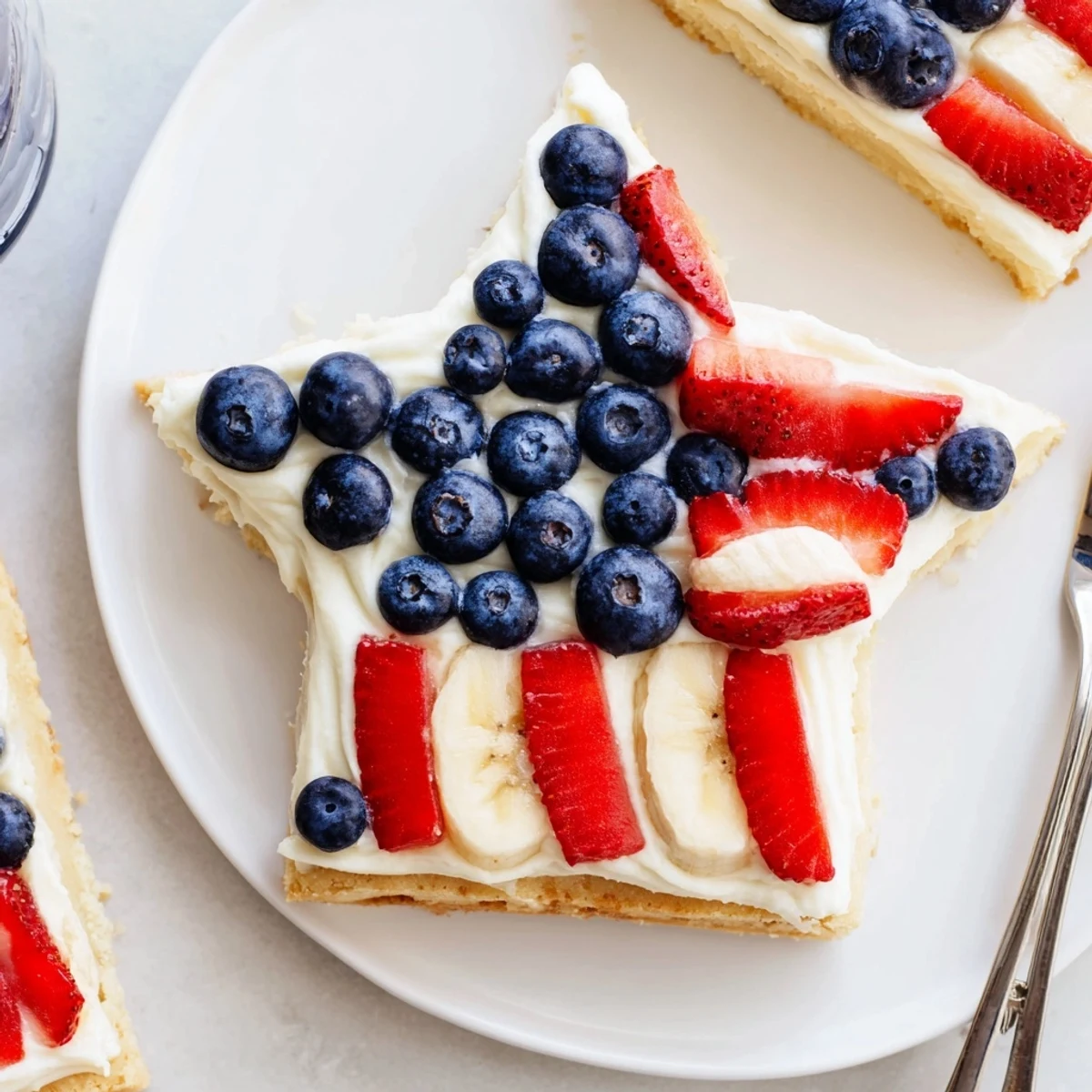 Chilled American Flag Fruit Pizza sliced into squares, juicy strawberries and blueberries
