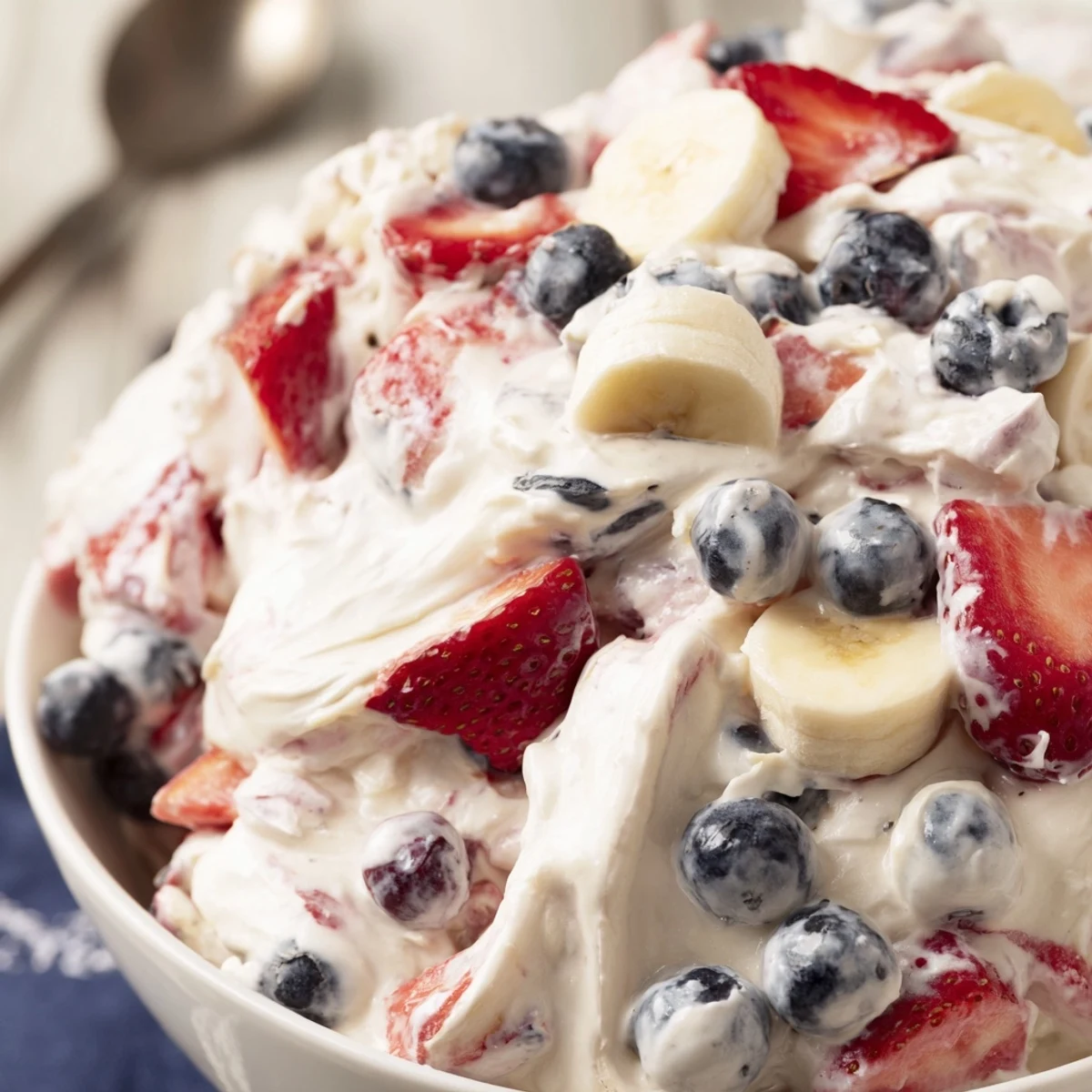 Red White And Blue Cheesecake Salad piled in bowl, creamy, berry-studded.