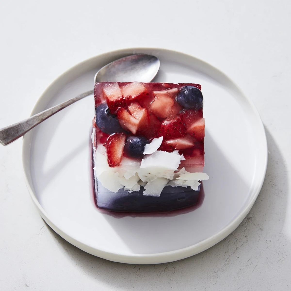 Vivid strawberries, blueberries layered with coconut in Red White And Blue Ice Cubes Recipe