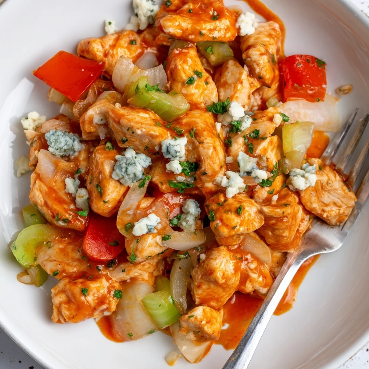 One-pan Keto Buffalo Chicken Skillet garnished with blue cheese, fragrant parsley
