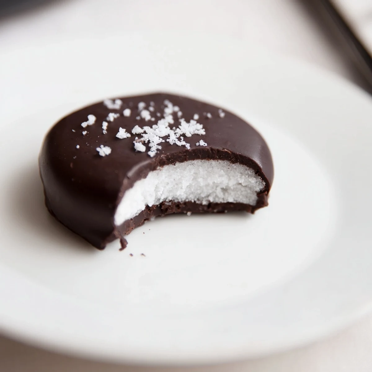 Peppermint Patties on parchment, glossy dark chocolate and snowy sugar centers