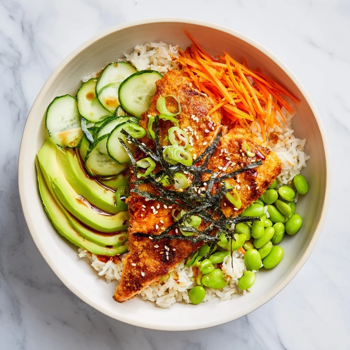 Vibrant crispy salmon and rice bowl drizzled with savory soy ginger sauce and topped with colorful vegetables