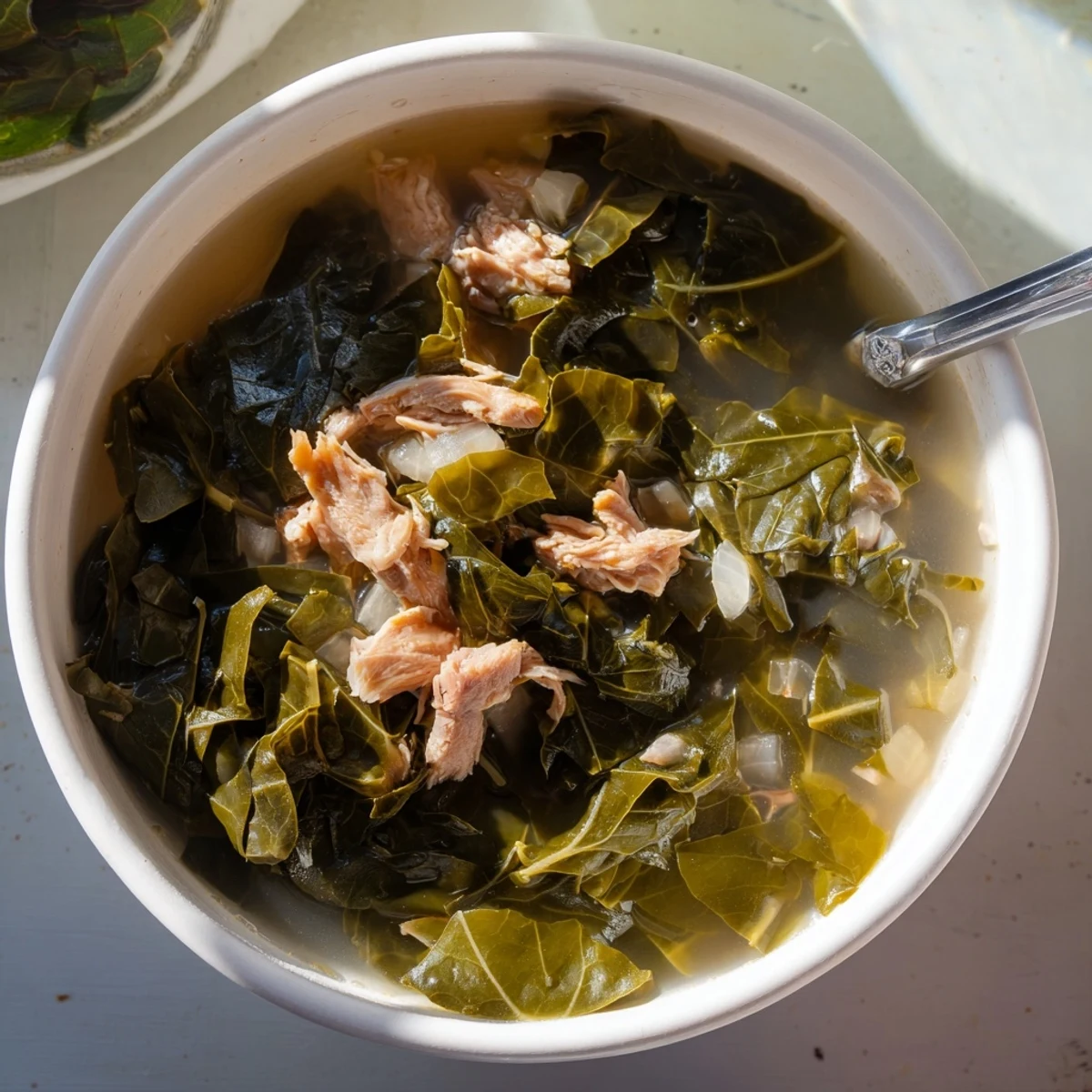 Soul food collard greens simmering in a deep pot with smoky broth and tender wilted leaves