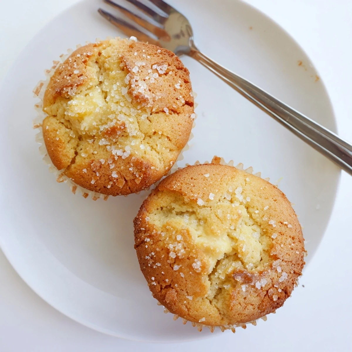 Batch of twelve lemon cream cheese muffins cooling in paper-lined muffin tin