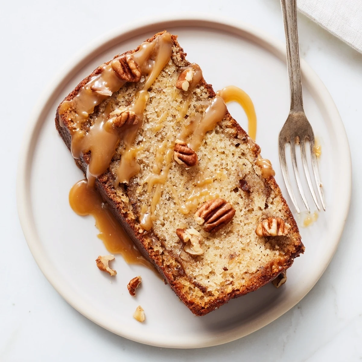Golden salted caramel brown butter banana cake slice with gooey caramel drizzle