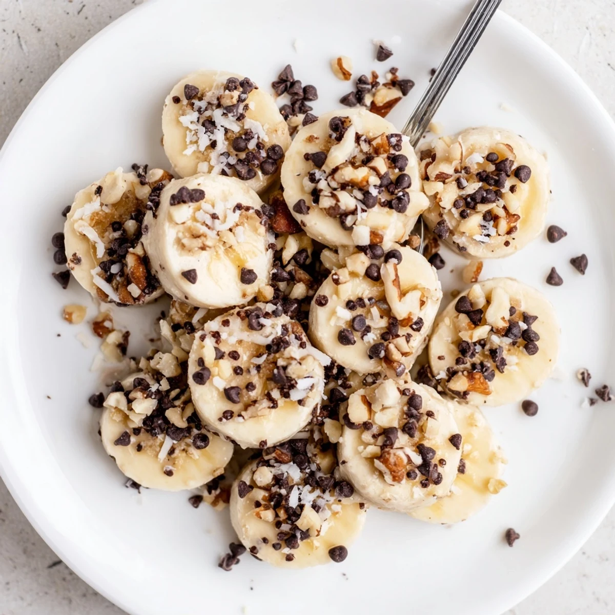 Frozen Banana Yogurt Bites: creamy, icy rounds on parchment, sprinkled with coconut