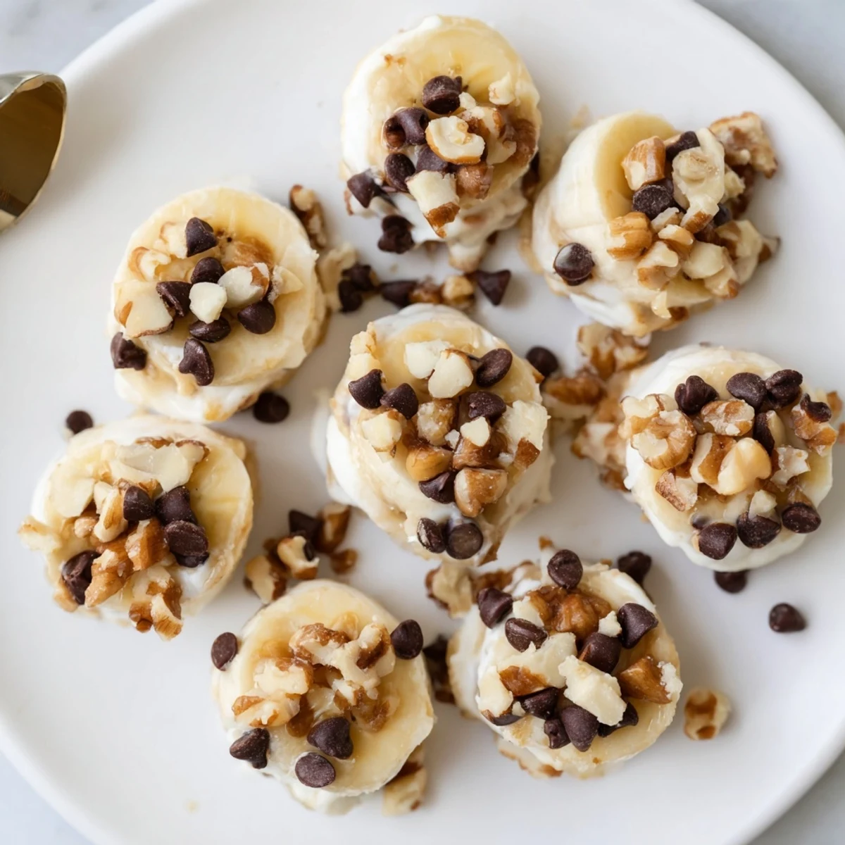 Sliced Frozen Banana Yogurt Bites chilled on a tray, dotted with chocolate